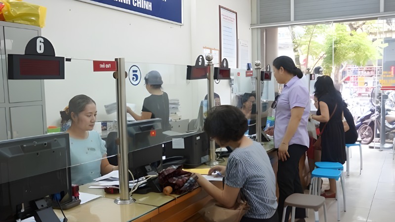 Cán bộ đang hướng dẫn người dân điền thông tin để giải quyết thủ thục BHXH (Nguồn: Tổng đài pháp luật)