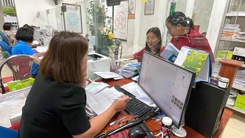 Cán bộ cơ quan BHXH Cơ sở Gia Lâm kiểm tra và tiếp nhận hồ sơ BHXH của người lao động